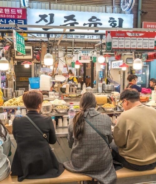 Seoul, South Korea - November 11, 2022 : shop and street food stall with many tourist at Gwangjang Market