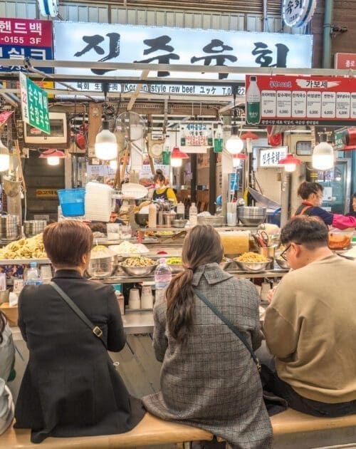 Seoul, South Korea - November 11, 2022 : shop and street food stall with many tourist at Gwangjang Market